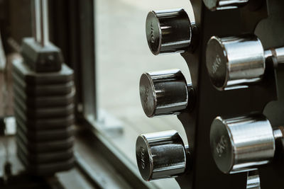 Close-up of dumbbells on rack in gym