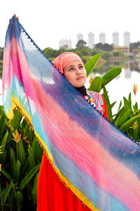 Portrait of young woman against multi colored sky