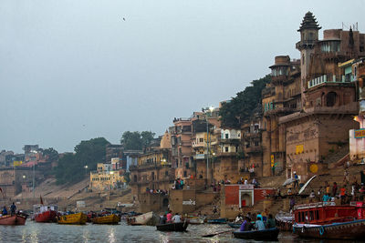 Boats in city against clear sky