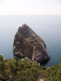 Rock formations by sea against sky