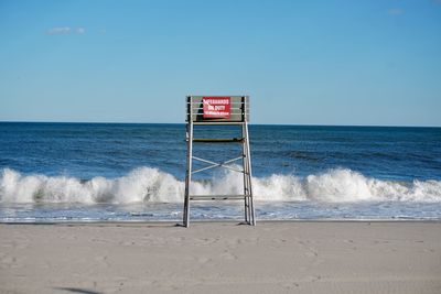 Lifeguard hut on beach against clear sky