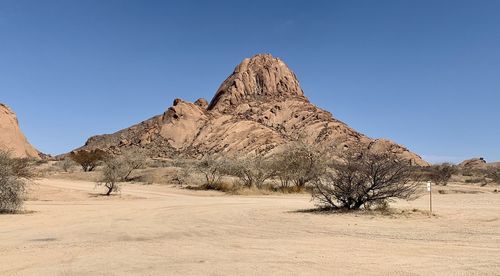 Scenic view of desert against clear blue sky