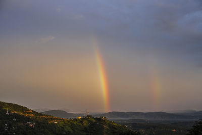 Scenic view of rainbow against sky during sunset. 