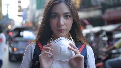 Portrait of beautiful woman drinking water from city