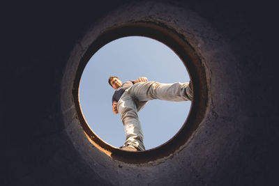 Directly below shot of man seen through hole against sky