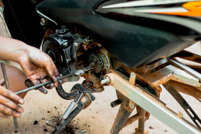 Midsection of man repairing motorcycle