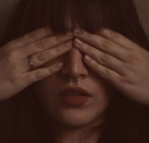 Close-up of woman with hands covering eyes