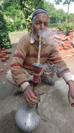 Full length of man sitting outdoors