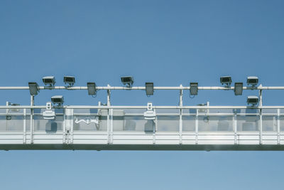 Low angle view of telephone pole against clear blue sky