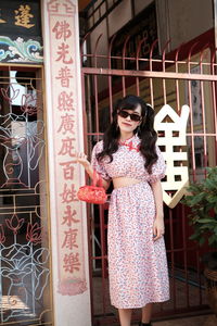 Portrait of woman in pink modern cheongsam at chinese temple 