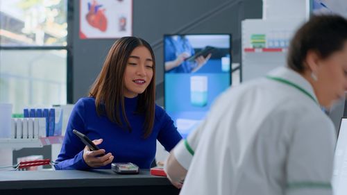 Portrait of young woman using mobile phone in office