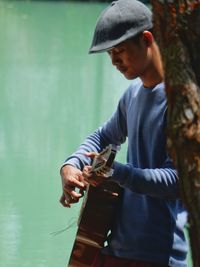 Side view of young man playing guitar