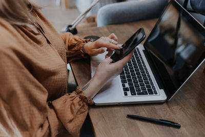 Midsection of woman using mobile phone