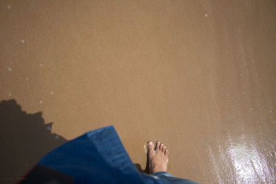 Low section of man relaxing on beach