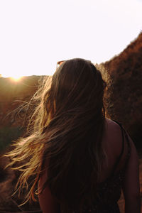 Rear view of young woman against clear sky