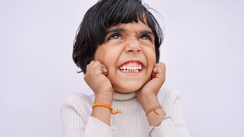 Portrait of young woman against white background