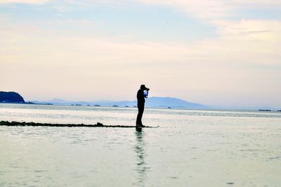 Man standing on beach against sky