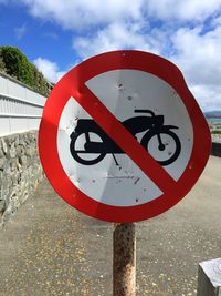 Close-up of road sign against sky