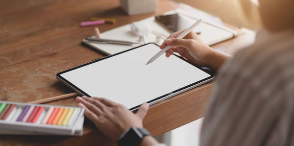 High angle view of woman using smart phone on table