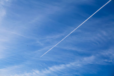 Low angle view of vapor trail in blue sky