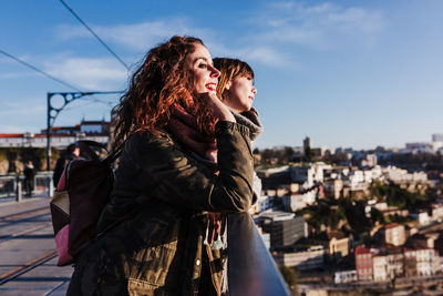 Two happy friends porto bridge sightseeing at sunset. travel, friendship and lifestyle