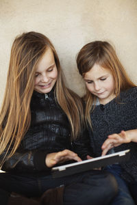 Portrait of two girls with digital tablet
