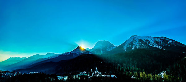 Scenic view of snowcapped mountains against blue sky