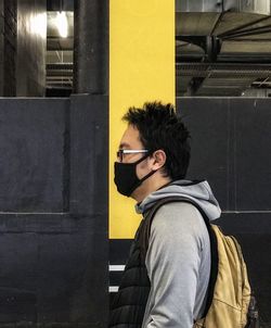 Portrait of young man against yellow pillar.