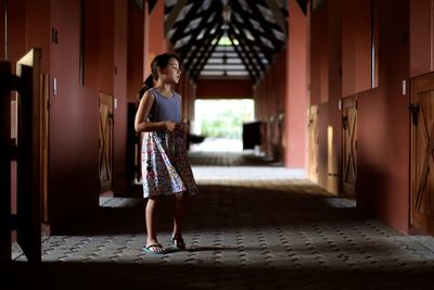 Front view of girl walking on aisle in stable