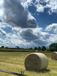 Hay bales on field against sky