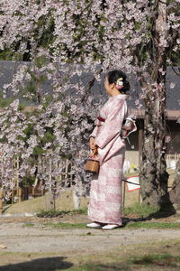 Woman standing by tree