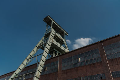 Low angle view of factory against blue sky