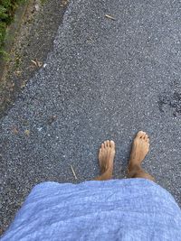 Low section of man standing on road