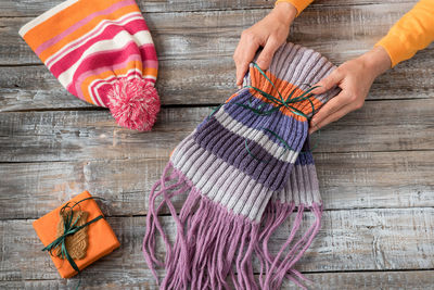 Cropped image of woman holding scarf on wooden table