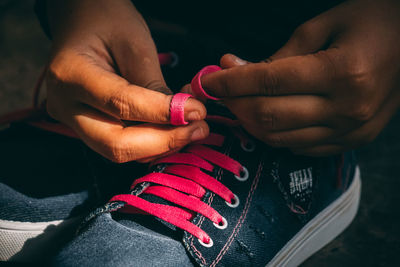 Cropped hands tying shoelace