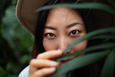 Close-up of young woman looking at camera in forest 