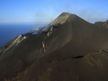Stromboli volcano by sea against sky