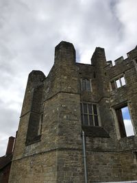 Low angle view of old building against cloudy sky