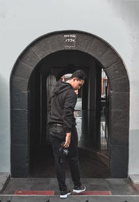 Side view of man looking through window