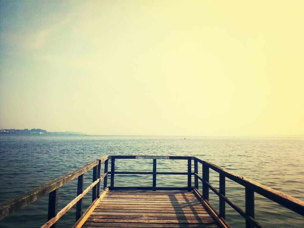 water, sea, railing, horizon over water, tranquil scene, pier, tranquility, scenics, beauty in nature, jetty, the way forward, nature, clear sky, copy space, sky, rippled, idyllic, wood - material, boardwalk, ocean