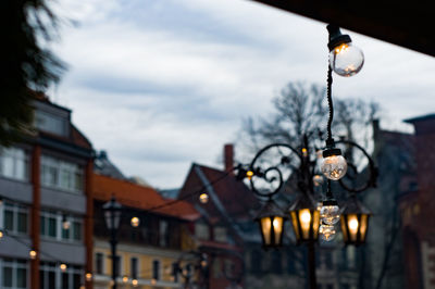 Low angle view of illuminated street light against buildings