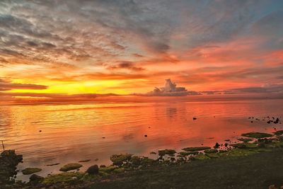 View of calm sea against cloudy sky during sunset