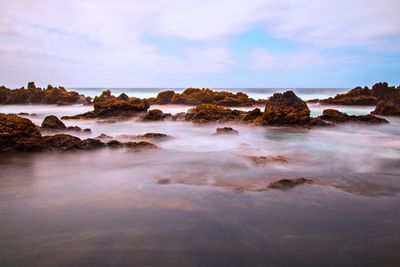 Rocks on beach against sky