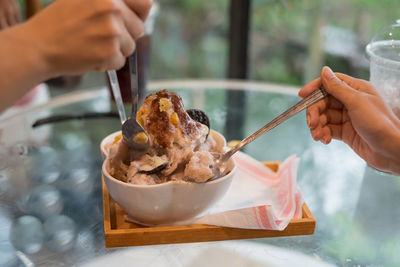 Close-up of hand holding ice cream on table