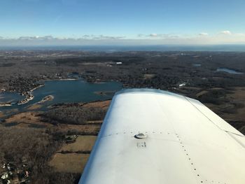 Aerial view of aircraft wing against sky