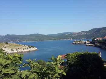 Scenic view of bay against clear blue sky