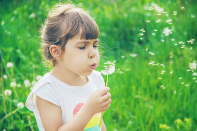 Close-up of boy blowing plants