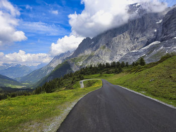 Road leading towards mountains against sky