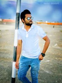 Young man wearing sunglasses standing outdoors