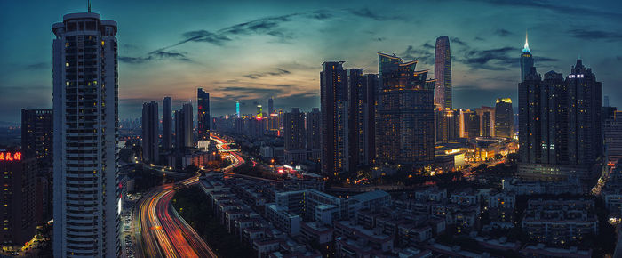 Illuminated buildings in city against sky